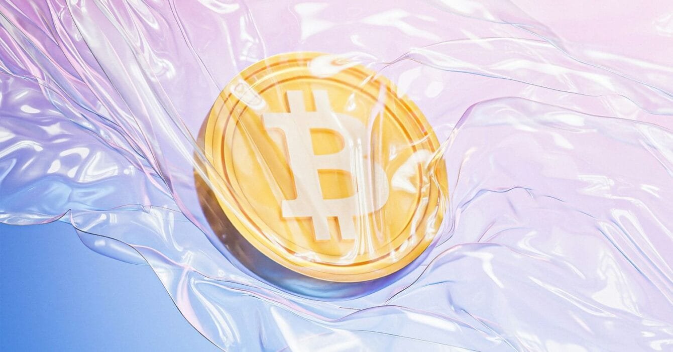 UAE crypto regulation 2025: A glowing Bitcoin coin partially submerged in translucent, colorful plastic, creating a surreal and modern visual effect.